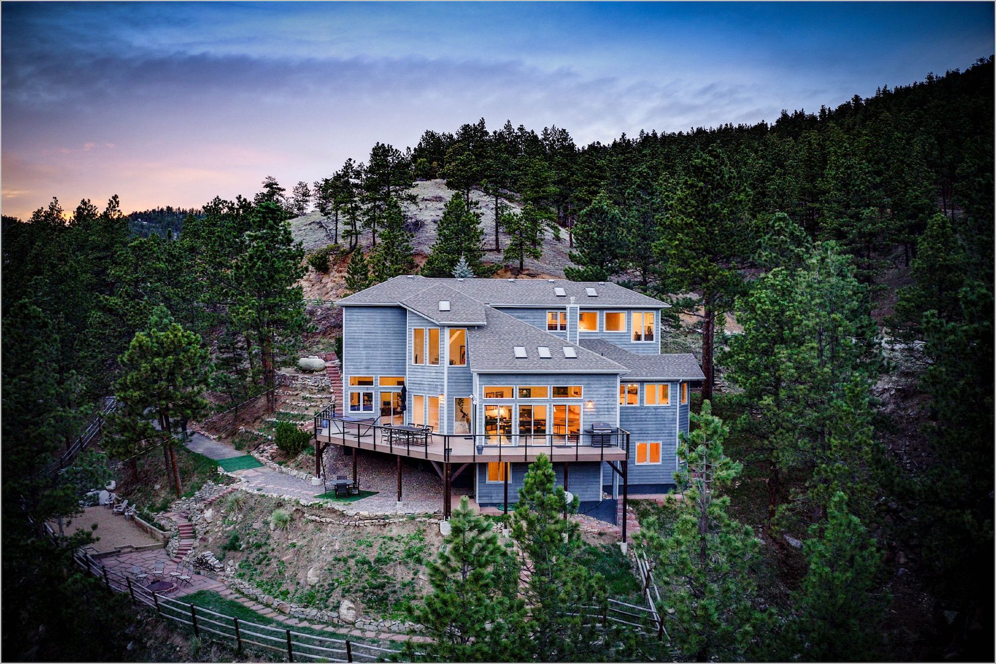 A mountain home built into the side of a hill at dusk