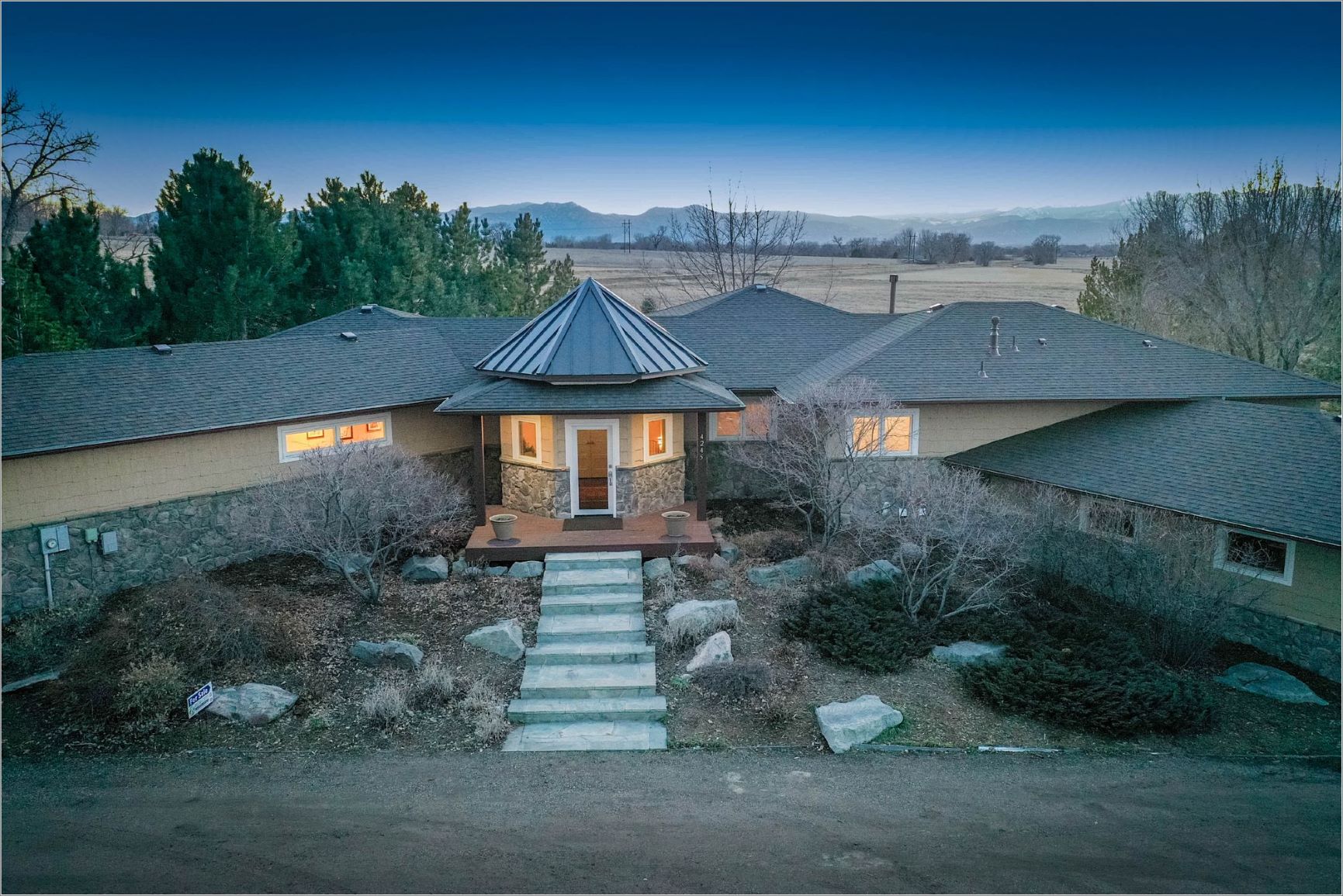 A ranch home at twilight with mountains in the distance